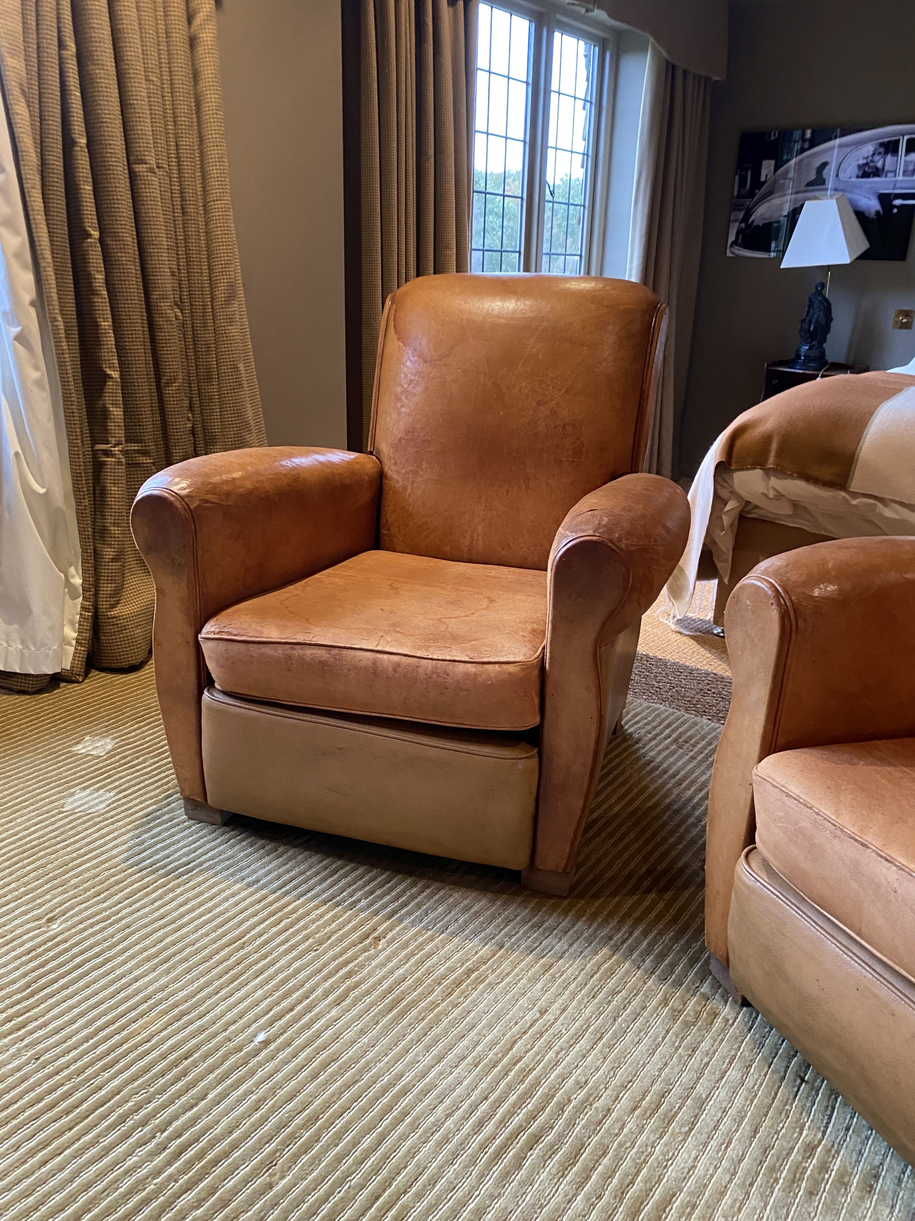 A pair of 1940's French tan leather upholstered armchairs, width 82cm depth 92cm height 84cm